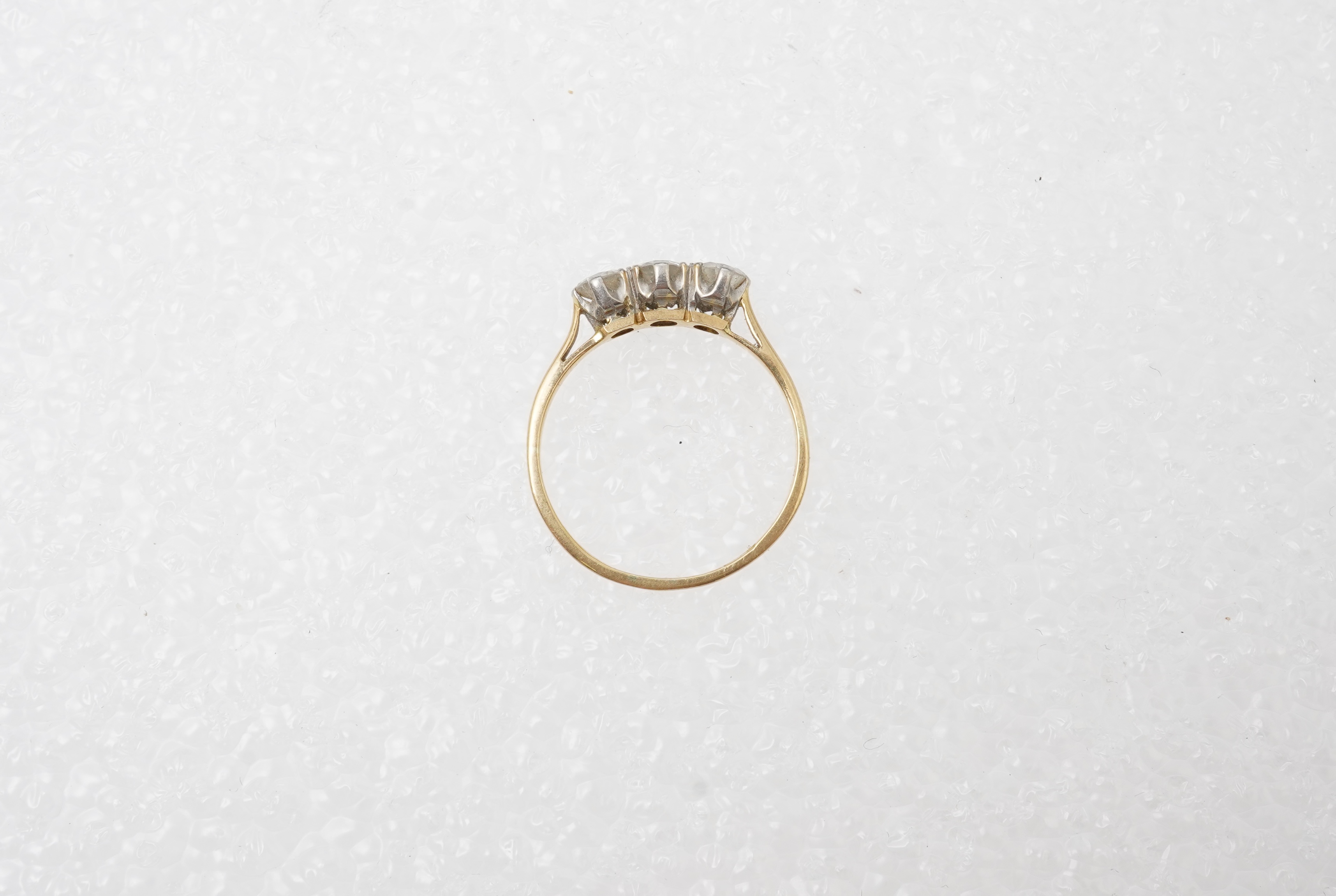 A diamond three-stone ring, set with three circular-cut diamonds totalling approximately 0.50 carats, mounted in gold, size O, stamped 18CT, gross weight approximately 2 grams